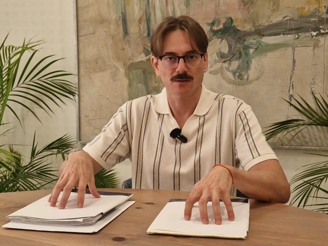 Andrey Prokopenkov Serov at his office in Marbella, with two folders of documents on the table